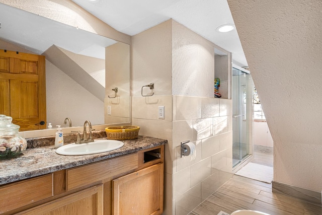 bathroom featuring hardwood / wood-style flooring, vanity, an enclosed shower, and vaulted ceiling