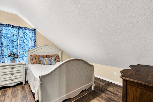 bedroom featuring dark hardwood / wood-style flooring, vaulted ceiling, and a textured ceiling