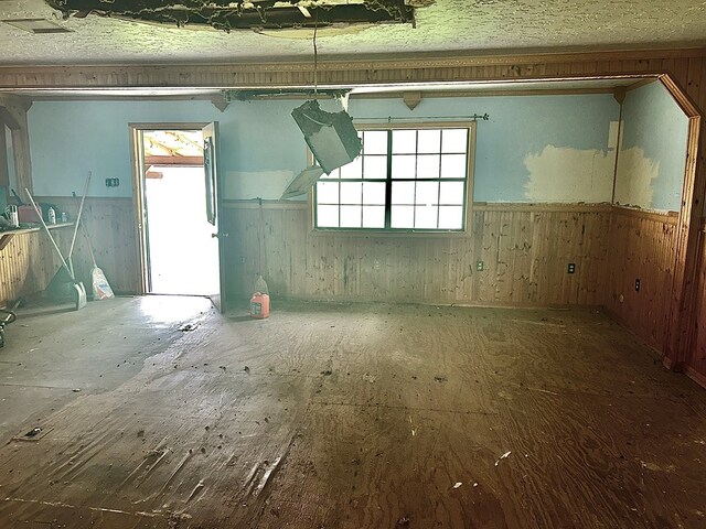 interior space featuring plenty of natural light, wooden walls, and wainscoting