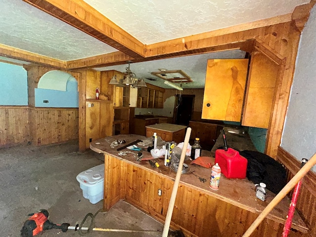 kitchen featuring wood walls and a textured ceiling