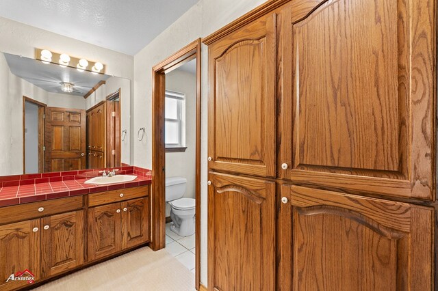 806 Cartwright, San Augustine, TX 75972 - bathroom featuring toilet, vanity, and tile patterned floors