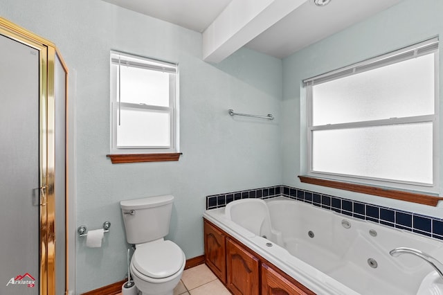 806 Cartwright, San Augustine, TX 75972 - bathroom with toilet, a tub with jets, tile patterned flooring, and baseboards