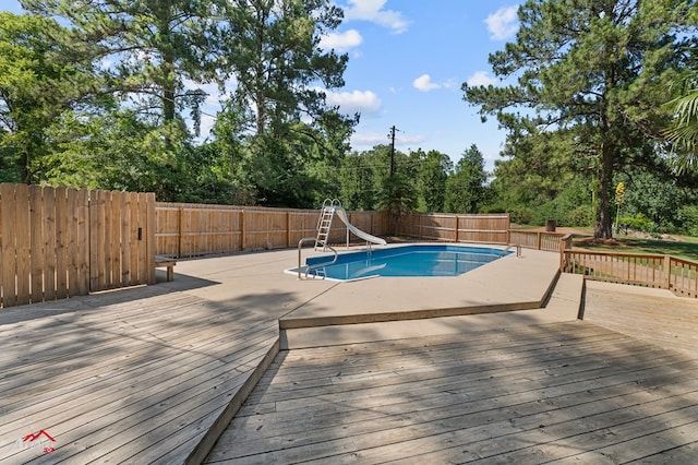 806 Cartwright, San Augustine, TX 75972 - view of swimming pool with a water slide, a fenced backyard, and a wooden deck