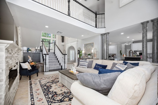 486 Brookwood Dr, Diboll, TX 75941 - living room featuring ornate columns, visible vents, a fireplace, and stairway