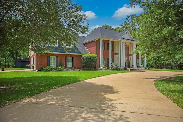 486 Brookwood Dr, Diboll, TX 75941 - neoclassical home featuring brick siding, a front yard, and roof with shingles