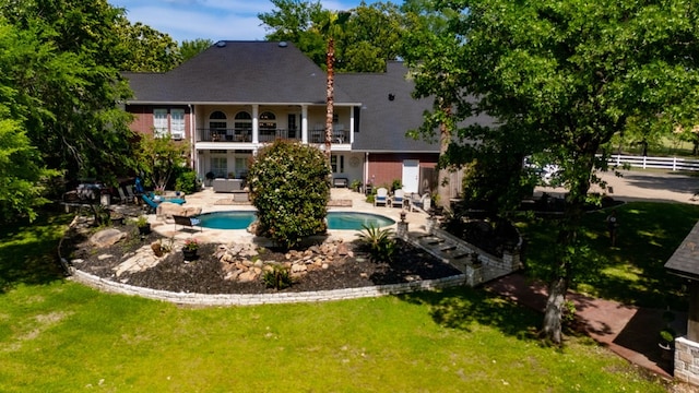 486 Brookwood Dr, Diboll, TX 75941 - back of house featuring fence, a balcony, an outdoor pool, a patio area, and a lawn