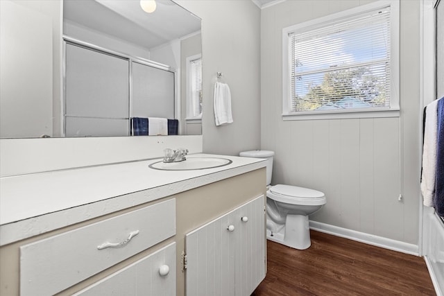 full bathroom featuring vanity, crown molding, wood-type flooring, enclosed tub / shower combo, and toilet