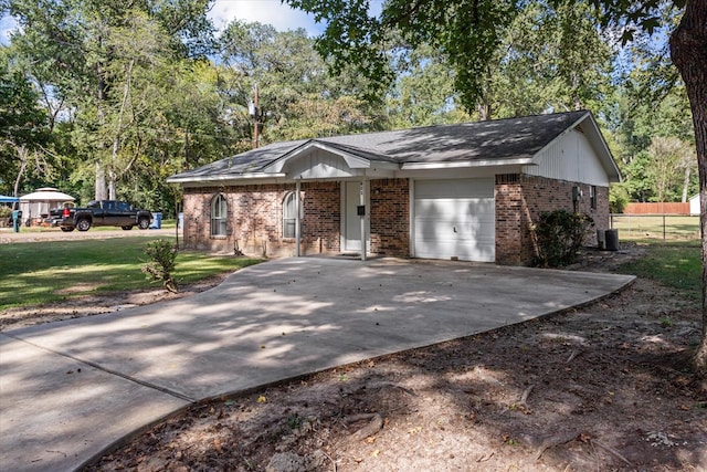 ranch-style home with a front lawn, central AC unit, and a garage