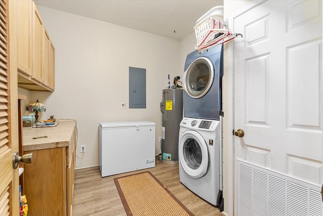 laundry room featuring cabinets, electric panel, stacked washer and dryer, water heater, and light hardwood / wood-style floors