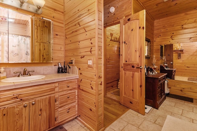 bathroom featuring wood walls, vanity, and wooden ceiling