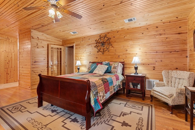 bedroom with wood ceiling, light hardwood / wood-style flooring, ceiling fan, and wood walls