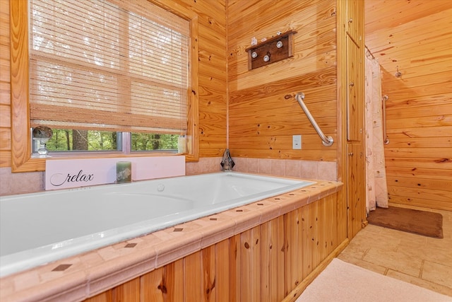 bathroom with tile patterned floors, wood walls, and a bath