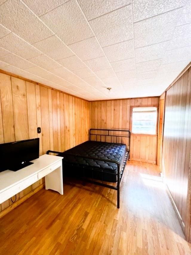 unfurnished bedroom featuring hardwood / wood-style flooring and wooden walls