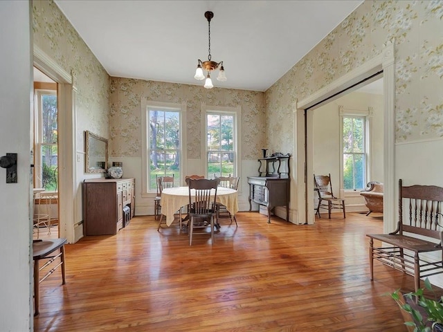 dining space featuring light wood-type flooring and a notable chandelier