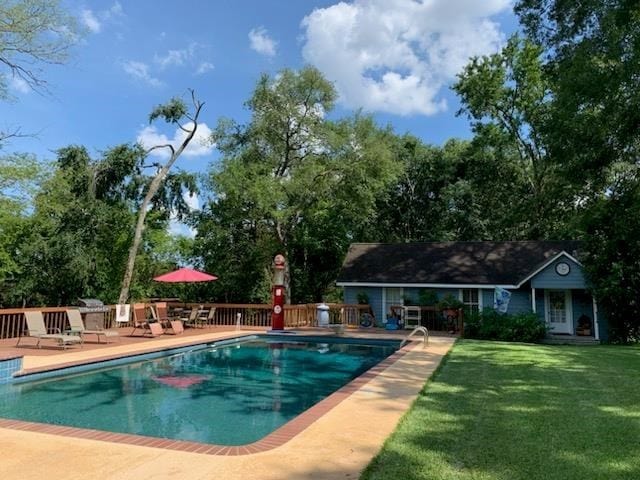 view of swimming pool featuring a patio area and a lawn