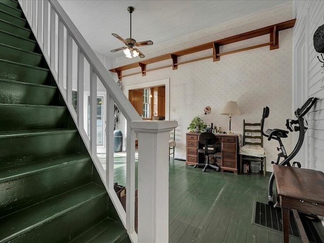 stairway with ceiling fan and wood-type flooring