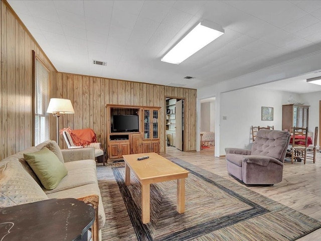 living room with wooden walls and light hardwood / wood-style floors