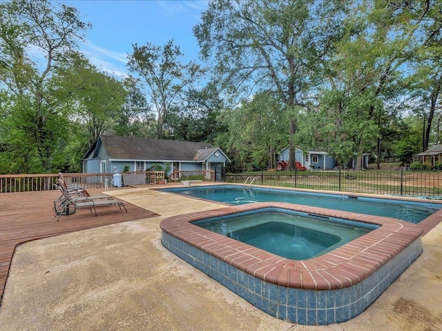 view of swimming pool featuring an in ground hot tub, an outbuilding, and a deck