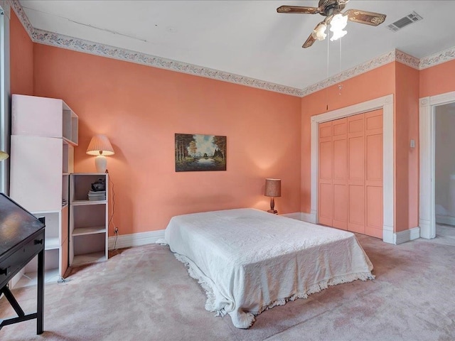 bedroom with ceiling fan, a closet, and light colored carpet