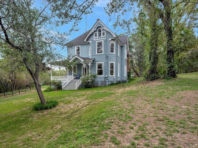 victorian-style house featuring covered porch and a front yard