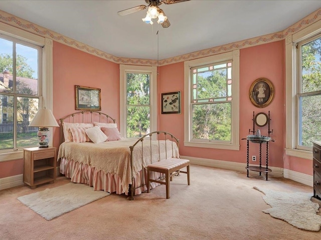 carpeted bedroom featuring ceiling fan and multiple windows