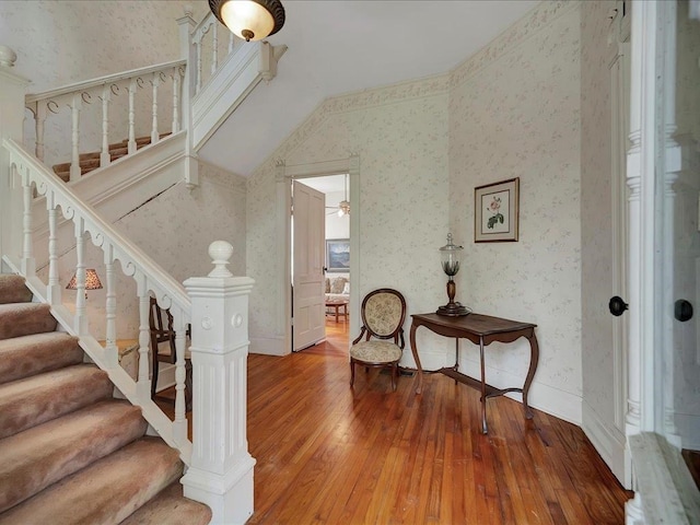 stairs featuring hardwood / wood-style flooring, ceiling fan, and vaulted ceiling