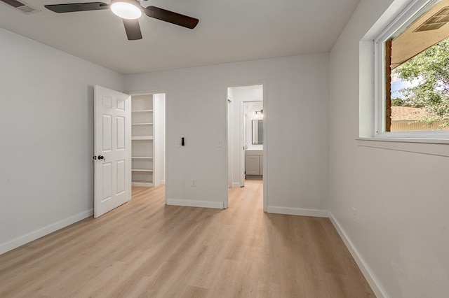 1311 Walnut Bend Dr, Lufkin, TX 75904 - unfurnished bedroom with light wood finished floors, a ceiling fan, and a spacious closet