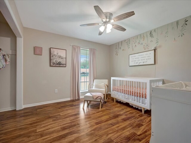 1304 Walnut Bend Dr, Lufkin, TX 75904 - bedroom featuring wood finished floors, a crib, baseboards, and a ceiling fan