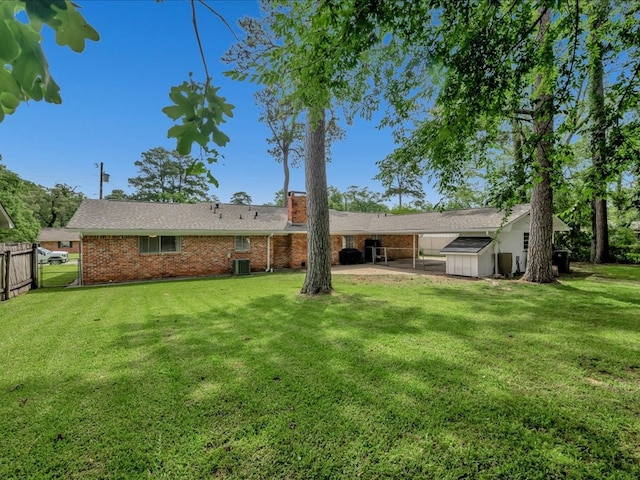 1304 Walnut Bend Dr, Lufkin, TX 75904 - back of house with a patio area, brick siding, a chimney, a storage shed, and an outdoor structure