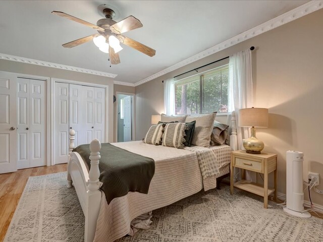 1304 Walnut Bend Dr, Lufkin, TX 75904 - bedroom with light wood-style floors, multiple closets, crown molding, baseboards, and ceiling fan