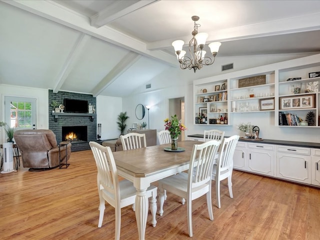 1304 Walnut Bend Dr, Lufkin, TX 75904 - dining space with a chandelier, a fireplace, and light wood-type flooring