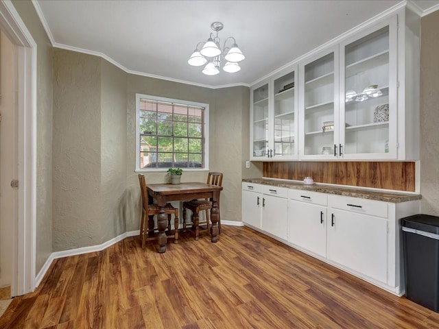 1304 Walnut Bend Dr, Lufkin, TX 75904 - dining space featuring a textured wall, wood finished floors, a chandelier, ornamental molding, and baseboards