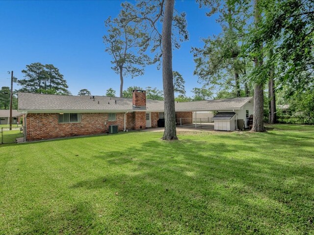 1304 Walnut Bend Dr, Lufkin, TX 75904 - back of property featuring a chimney, cooling unit, brick siding, a shed, and an outbuilding