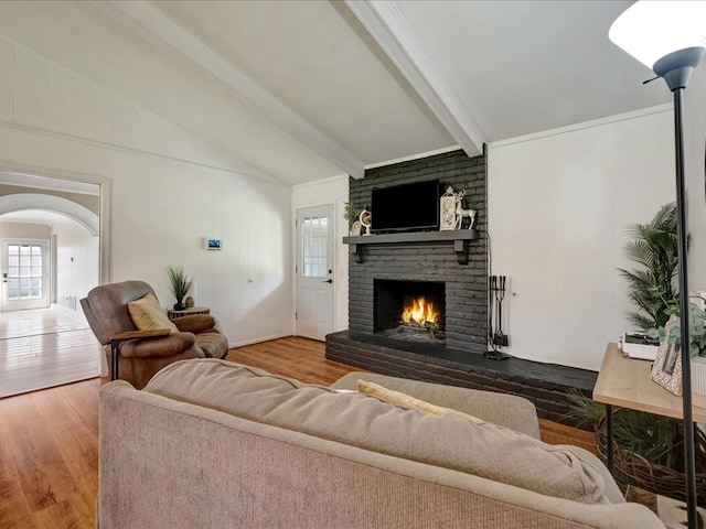 1304 Walnut Bend Dr, Lufkin, TX 75904 - living room featuring a brick fireplace, wood finished floors, and arched walkways