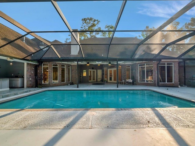 outdoor pool with french doors, ceiling fan, a patio, and glass enclosure