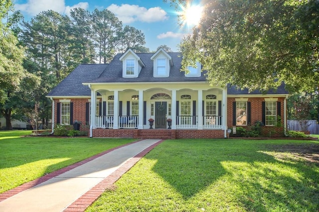 703 Shady Ln, Diboll, TX 75941 - cape cod home featuring covered porch, a front lawn, brick siding, and a shingled roof