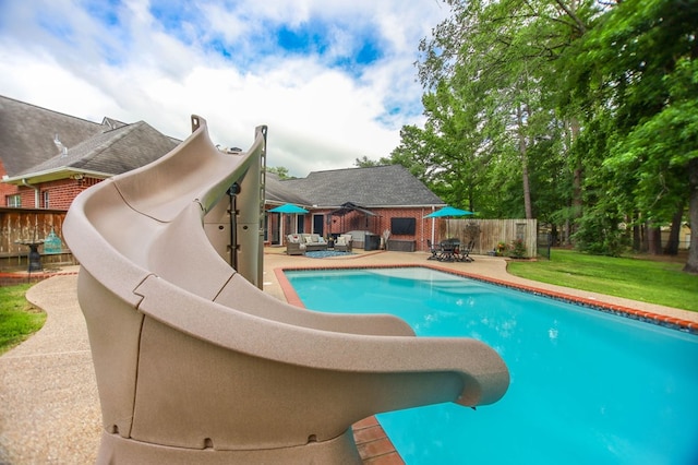 703 Shady Ln, Diboll, TX 75941 - view of swimming pool featuring a water slide, a patio area, and an outdoor living space