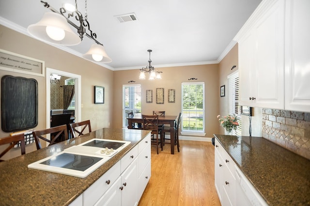 703 Shady Ln, Diboll, TX 75941 - kitchen with white electric cooktop, white cabinets, light wood finished floors, pendant lighting, and crown molding