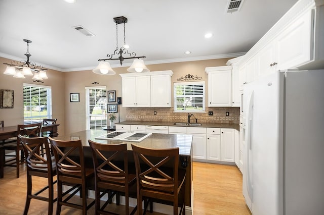 703 Shady Ln, Diboll, TX 75941 - kitchen with white appliances, white cabinetry, plenty of natural light, backsplash, and crown molding