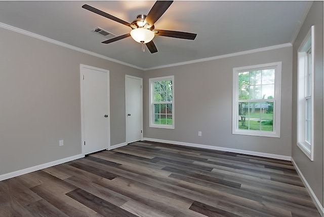 spare room featuring crown molding, ceiling fan, dark wood-type flooring, and visible vents