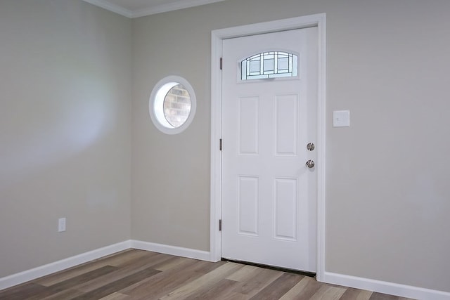 entrance foyer featuring crown molding, baseboards, and wood finished floors