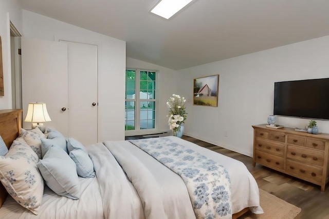 bedroom with vaulted ceiling and wood finished floors