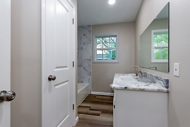 full bathroom featuring bathtub / shower combination, wood finished floors, vanity, baseboards, and toilet