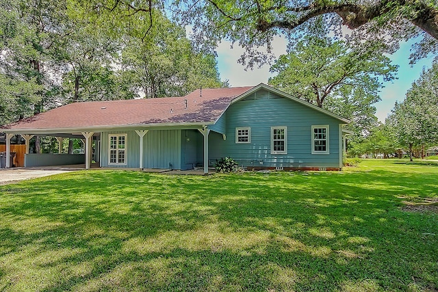 ranch-style home featuring board and batten siding, a front yard, and an attached carport