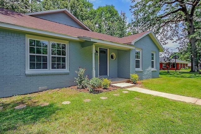 single story home featuring brick siding and a front yard