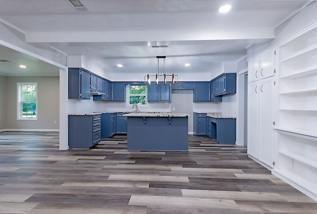 kitchen featuring a kitchen island, blue cabinetry, light countertops, dark wood-style floors, and under cabinet range hood