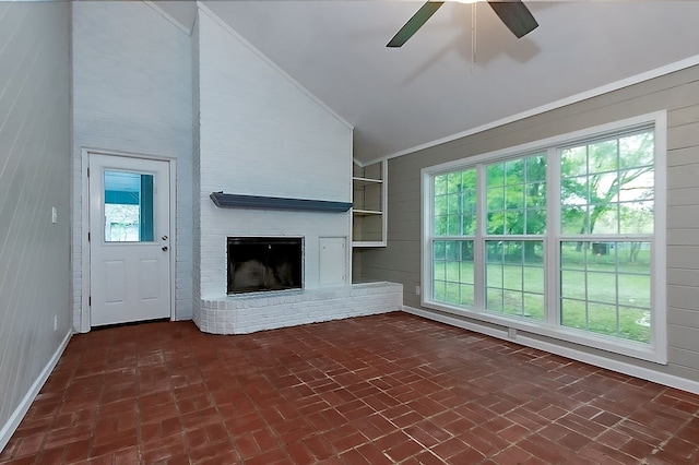 unfurnished living room with a ceiling fan, vaulted ceiling, a healthy amount of sunlight, and brick floor