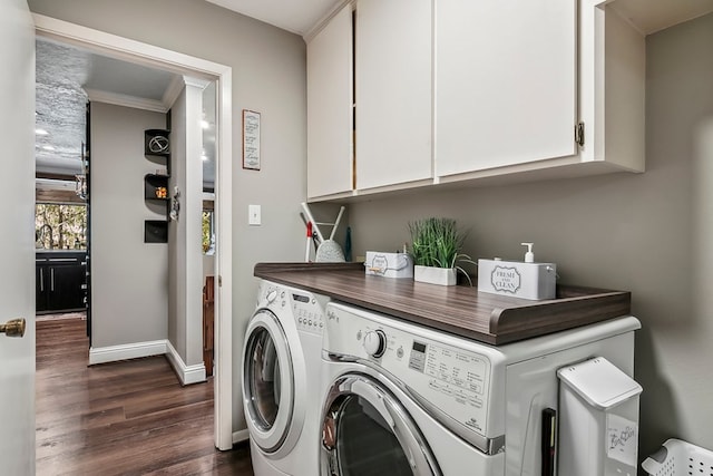 laundry area with washer and dryer, dark wood-type flooring, cabinets, and ornamental molding