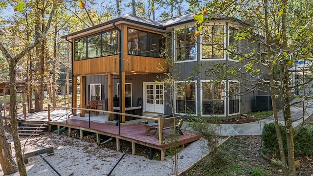 rear view of house with a wooden deck and a sunroom