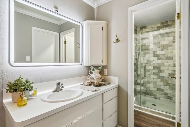 bathroom featuring crown molding, vanity, wood-type flooring, and walk in shower